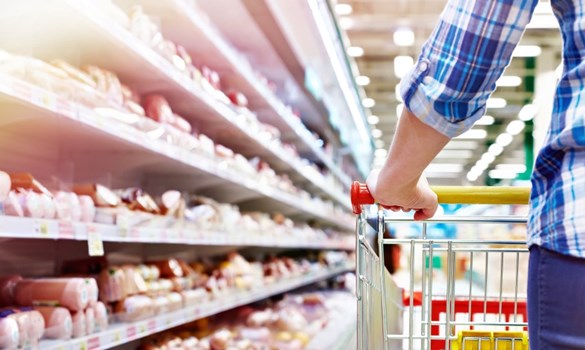 A person pushing a trolley in a supermarket aisle